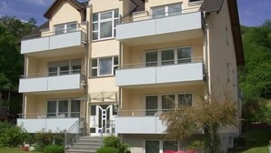 A multi-story residential building with balconies, a central entrance, and a surrounding garden. - Boardinghouse Hähn (Koblenz)