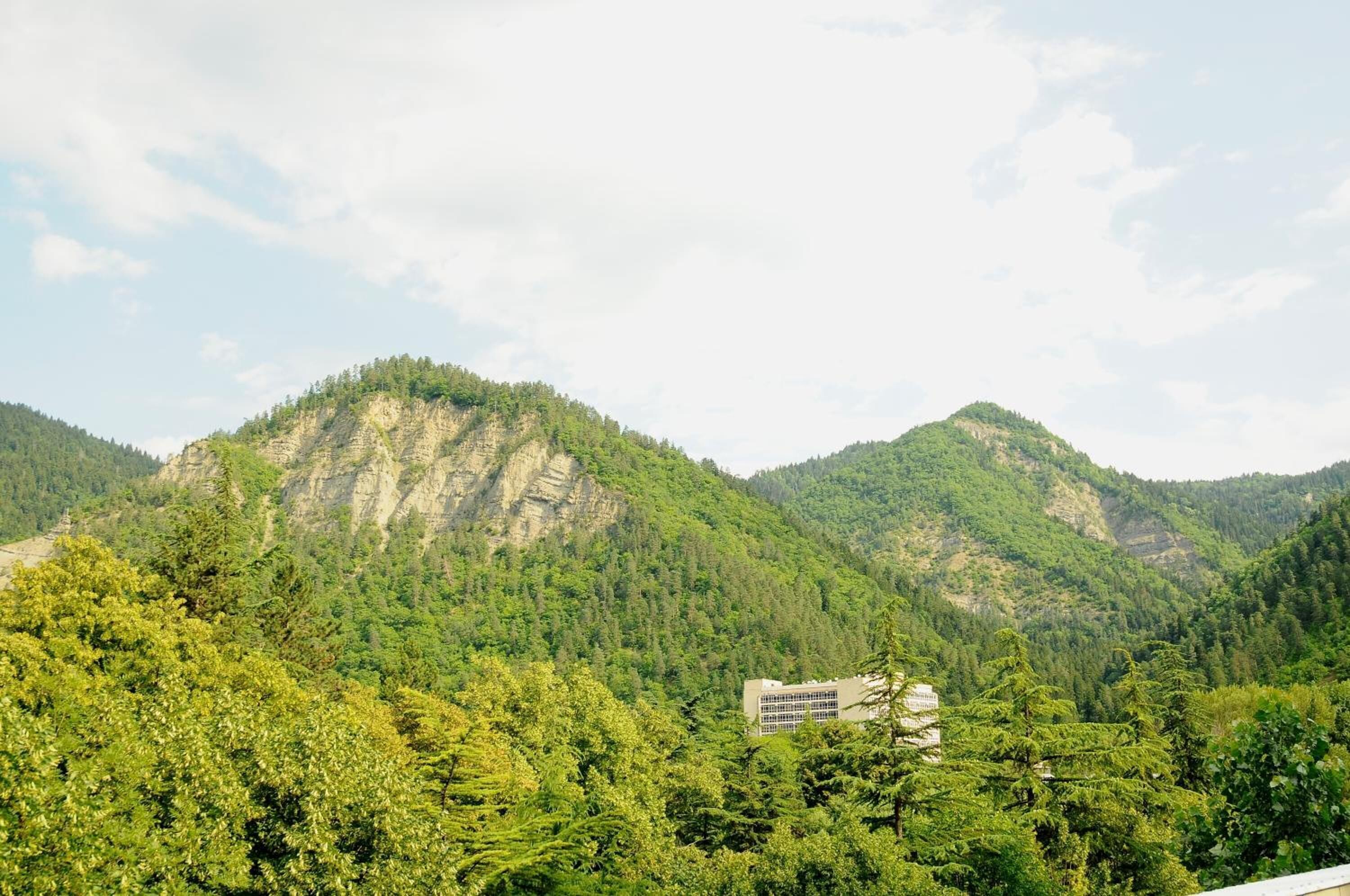 A mountain landscape with a building nestled among trees.