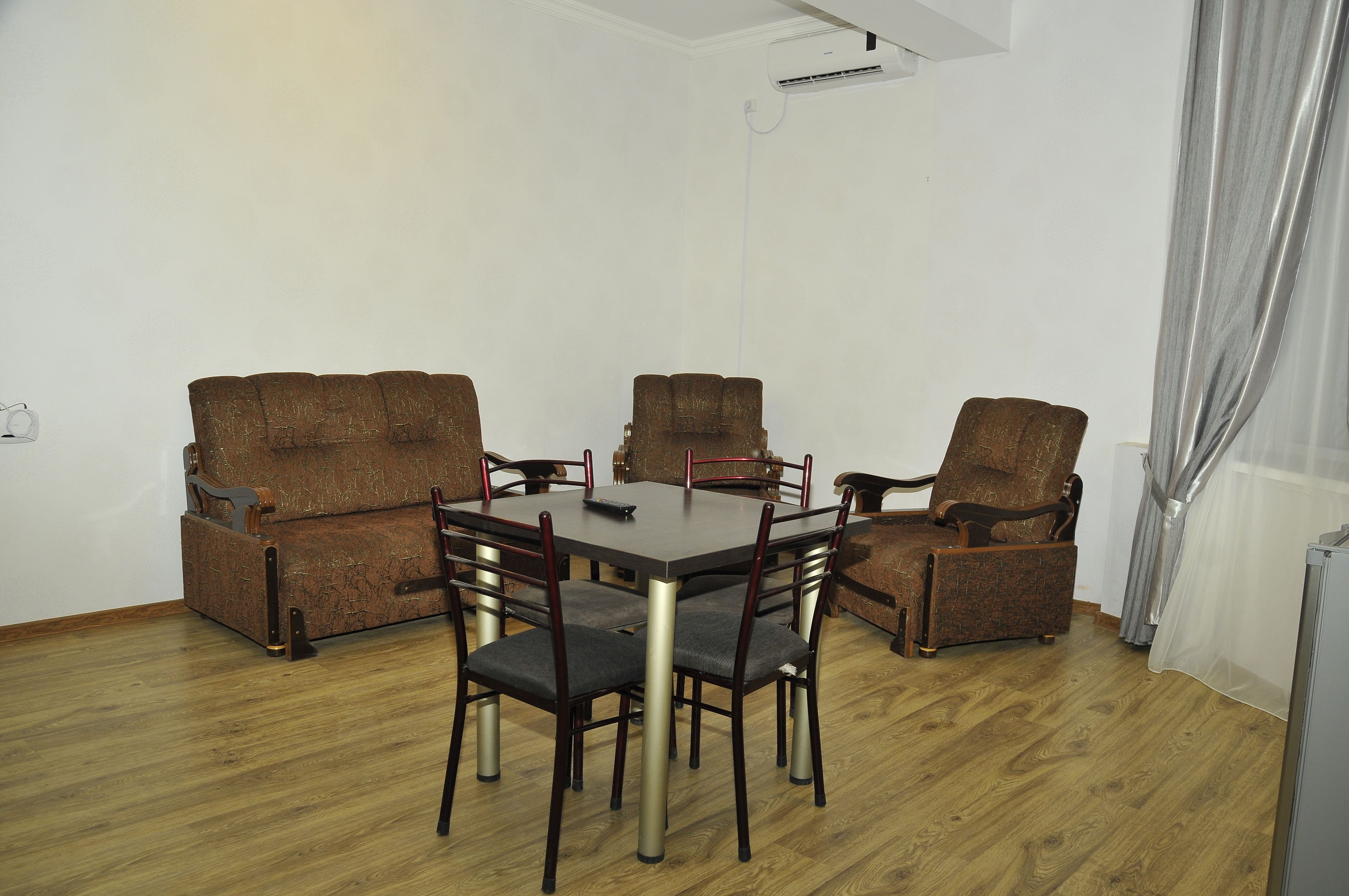 Un comedor con una mesa de madera y seis sillas, un sofá y un televisor.