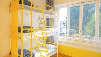Dormitorio con literas, vista por la ventana, una escalera y un panel de control.