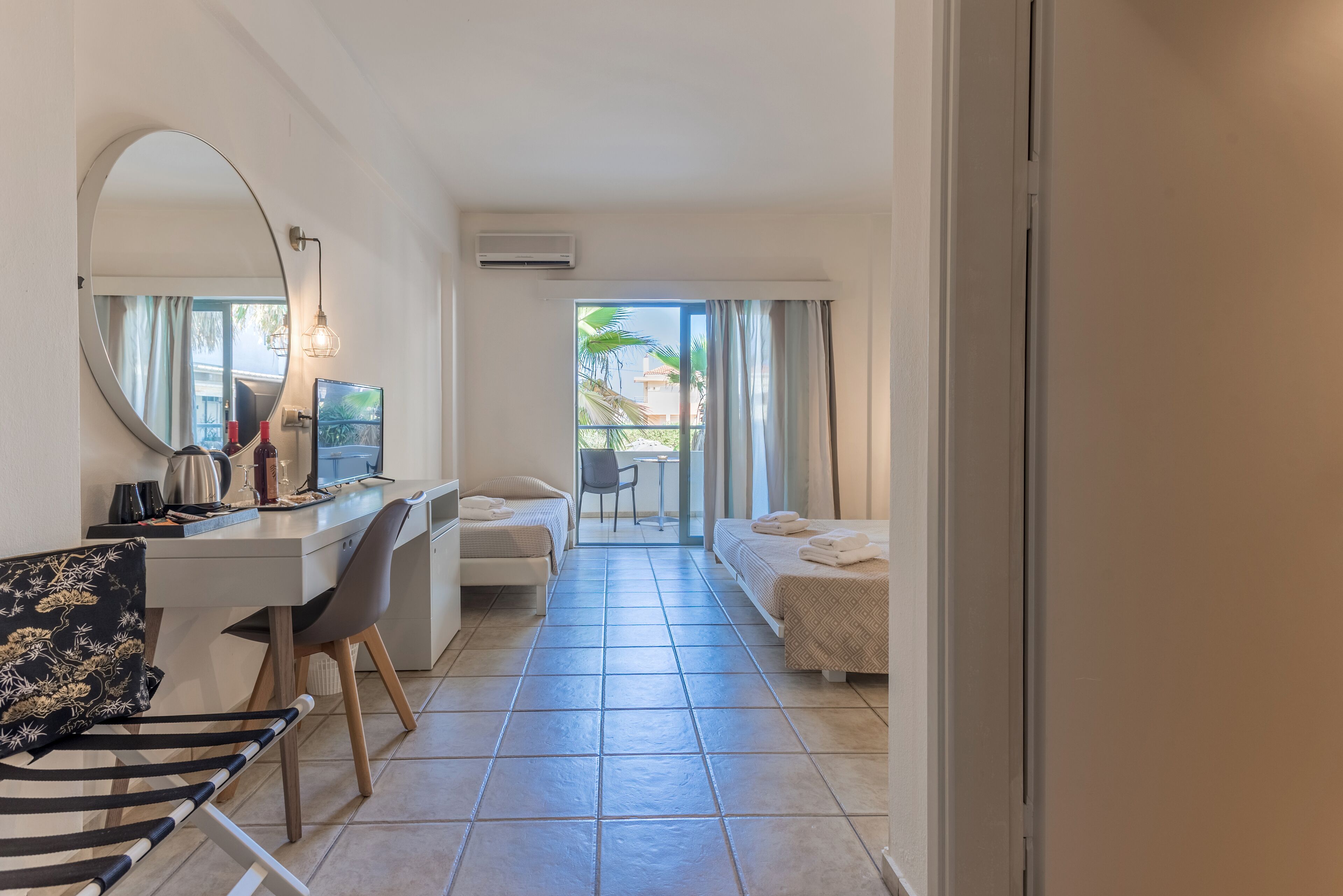 Habitación de hotel con escritorio, silla, cama y un espejo grande.