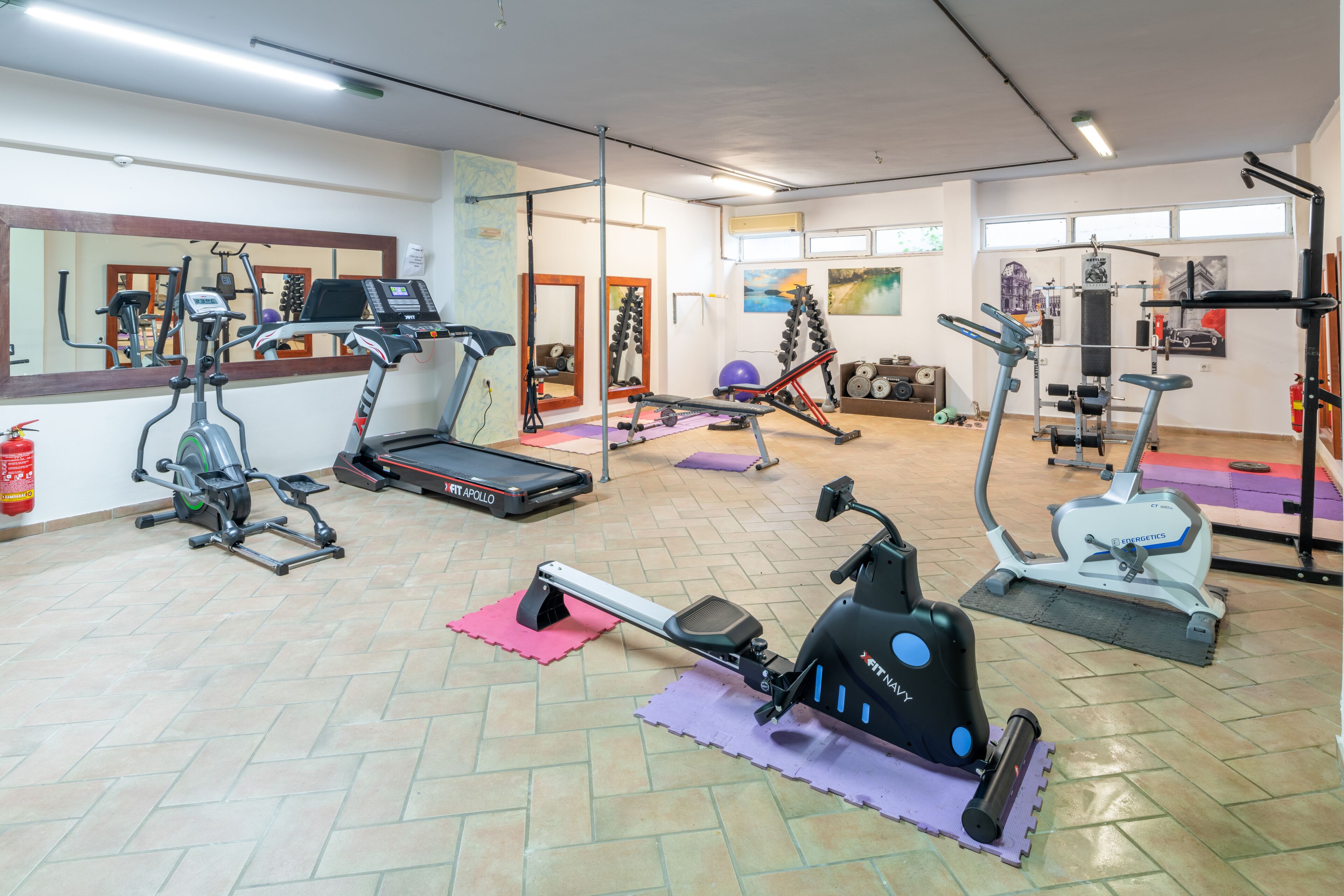 A gym with various exercise equipment, including treadmills, stationary bikes, and weight machines.