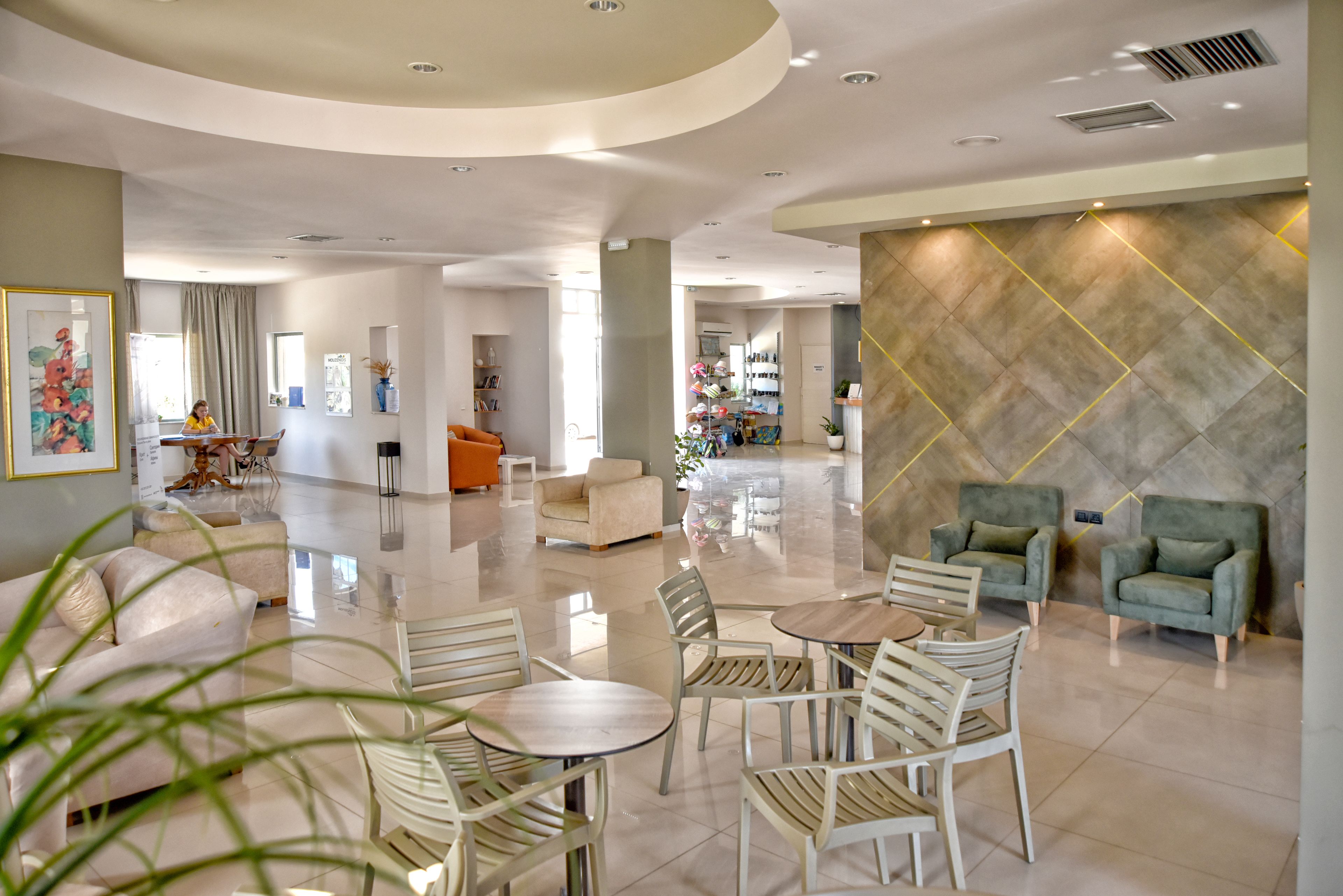 Un hall amplio con una zona de estar central, una mesa de recepción y un diseño de pared moderno.