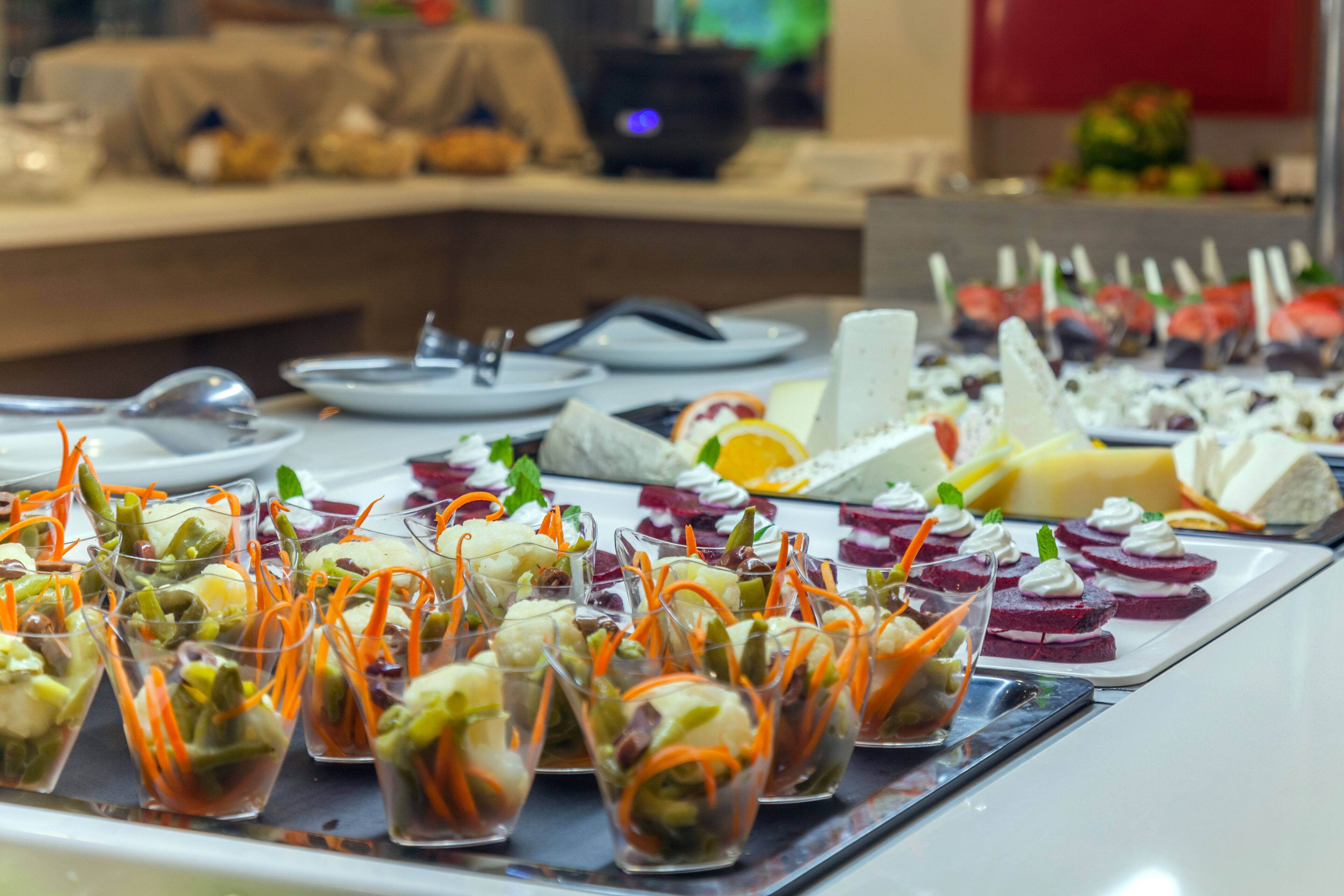 A buffet with various food items including appetizers in small glasses and a variety of other dishes.