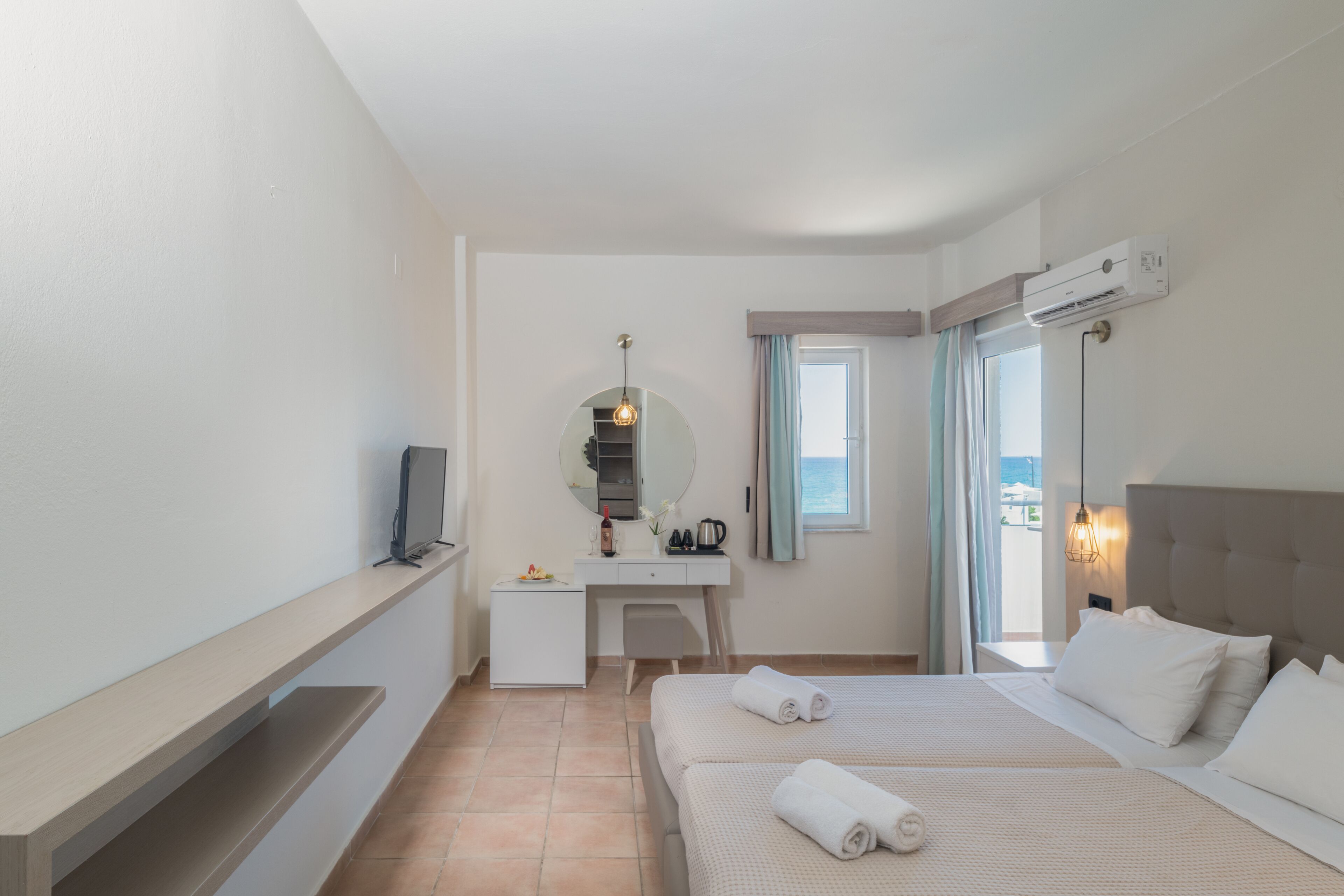 Une chambre d’hôtel équipée d’un lit, d’un bureau, d’une télévision, d’un miroir et d’un appareil de climatisation.