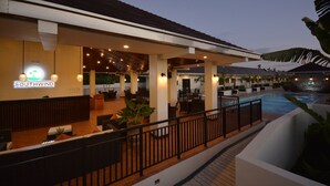 Vestíbulo de hotel con zona de piscina, mobiliario exterior y un letrero que dice 'Southwind'.