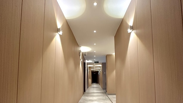 A long, narrow hallway with wooden paneling on both sides and a tiled floor. - Mika Hotel (Ulaanbaatar)