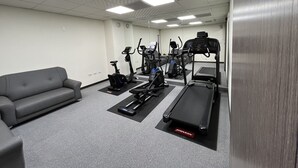 Ett träningsrum med löpband, crosstrainer och motionscyklar.