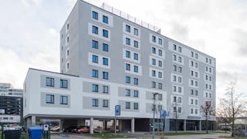 Un hôtel à plusieurs étages au design moderne, doté d’un parking et d’une entrée abritée.