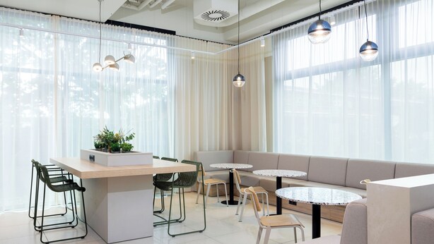 Ein modernes Interieur mit Essbereich, Sitzgelegenheiten und Pendelleuchten.