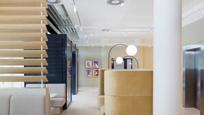 Ein modernes Interieur mit Sitzgelegenheiten, einer Wandgalerie und einem Aufzug.