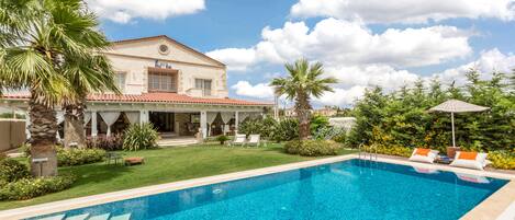 Een buitenzwembad en ligstoelen