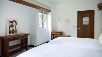 Un dormitorio con una cama grande, una mesita de noche de madera, un escritorio y una ventana.