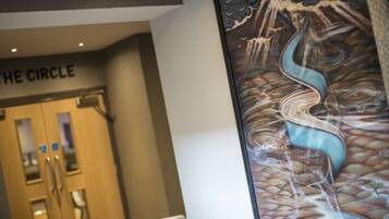 A hotel entrance with a sign reading "THE CIRCLE" and a large abstract painting on the wall.
