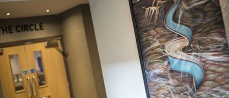 A hotel entrance with a sign reading "THE CIRCLE" and a large abstract painting on the wall.