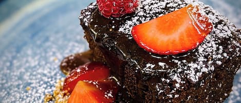 Un postre con fresas y frambuesas en un plato.