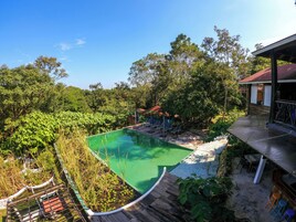 Una piscina al aire libre, sombrillas, sillones reclinables de piscina