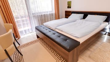 Un dormitorio moderno con una cama grande, un cabecero de madera y un banco al pie de la cama.