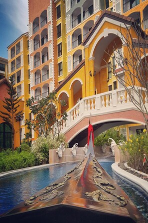 A hotel with a swimming pool featuring a decorative bridge and statues. - The Symphony Suites Pattaya (Pattaya)