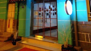 A building with a neon sign indicating a coffee, beer, and billiards establishment. - 25 Four Seasons Youth Hostel (Qingdao)