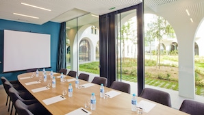 A conference room with a long table, chairs, water bottles, and a whiteboard. - Residhome Paris Gare de Lyon - Jacqueline De Romilly (Paris)