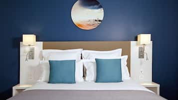A hotel room with a large bed, two nightstands, and a wall-mounted picture.