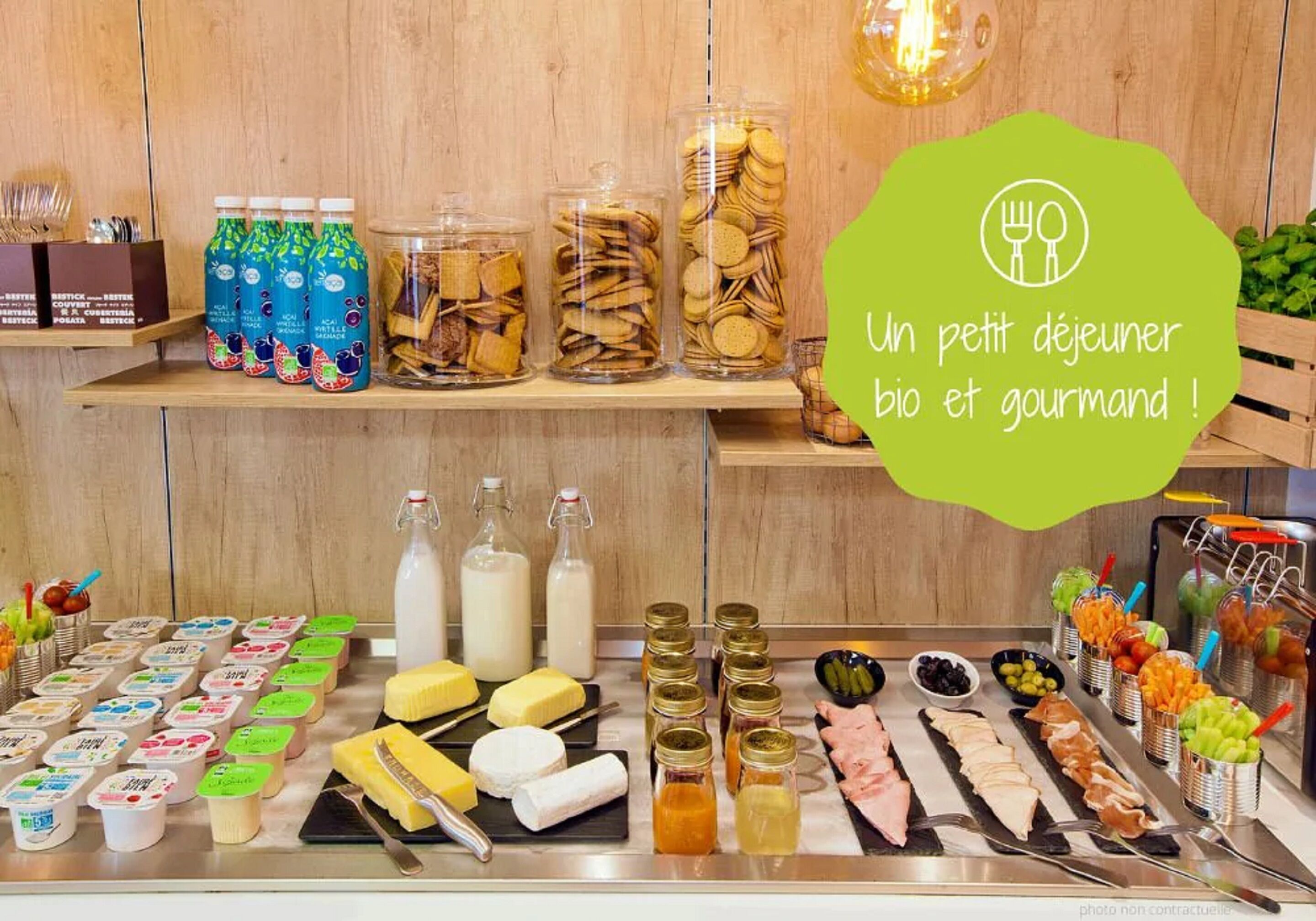 A buffet with various food and drink options, including yogurt, cheese, meats, and condiments.