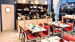 A modern cafe with wooden furniture, red chairs, and a variety of food items displayed on shelves. - Residhome Paris Gare de Lyon - Jacqueline De Romilly (Paris)