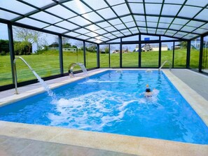 An indoor swimming pool with a glass ceiling, surrounded by a grassy area. - Hotel La Casa del Abuelo (Tapia de Casariego)