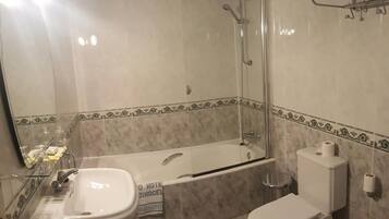 Un baño con bañera, inodoro y lavamanos.