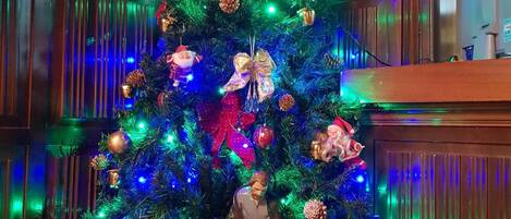 A Christmas tree with ornaments and lights, a nativity scene, and a wooden staircase.