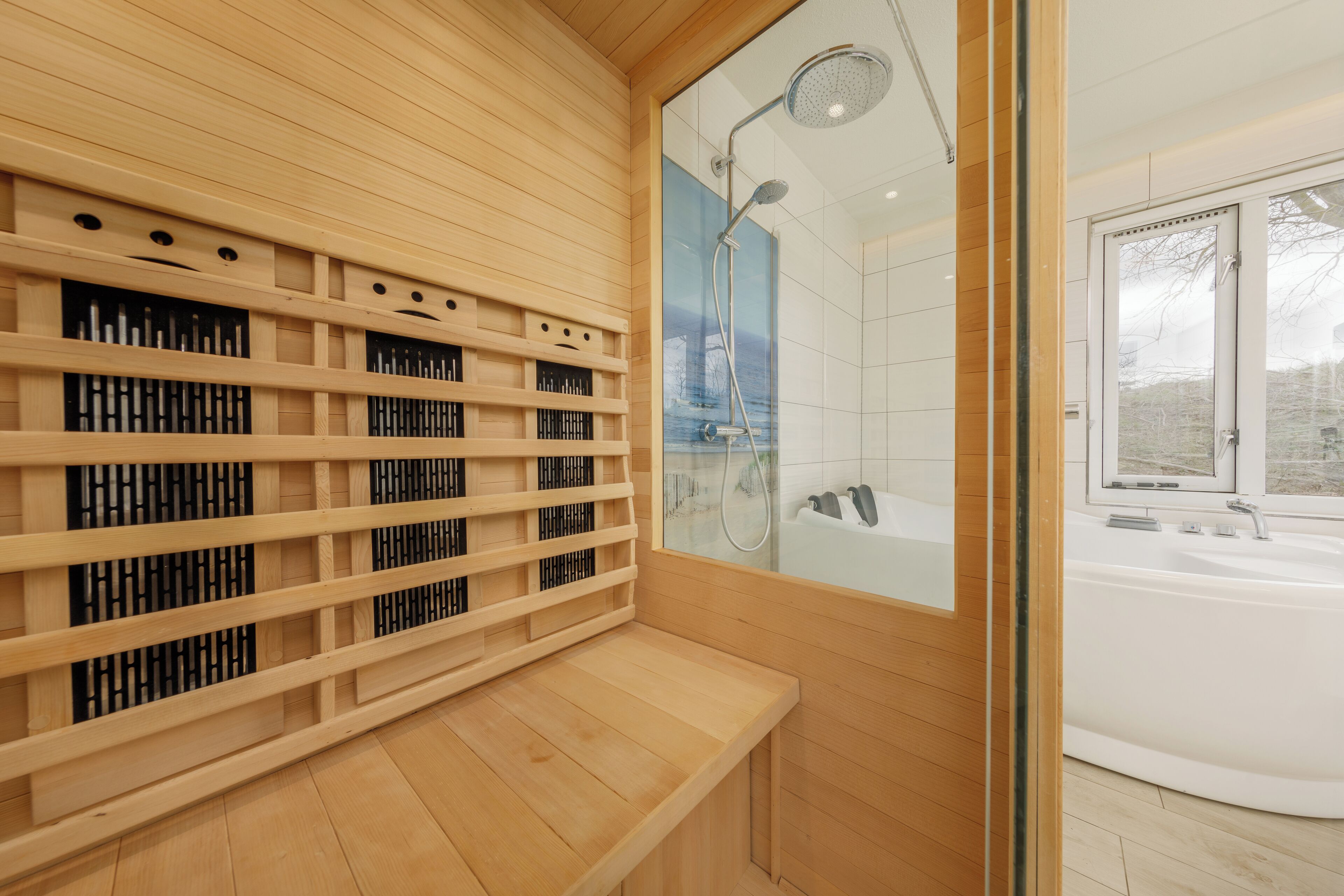 Een moderne badkamer met een houten bankje, een douche met glazen wanden en een witte badkuip.