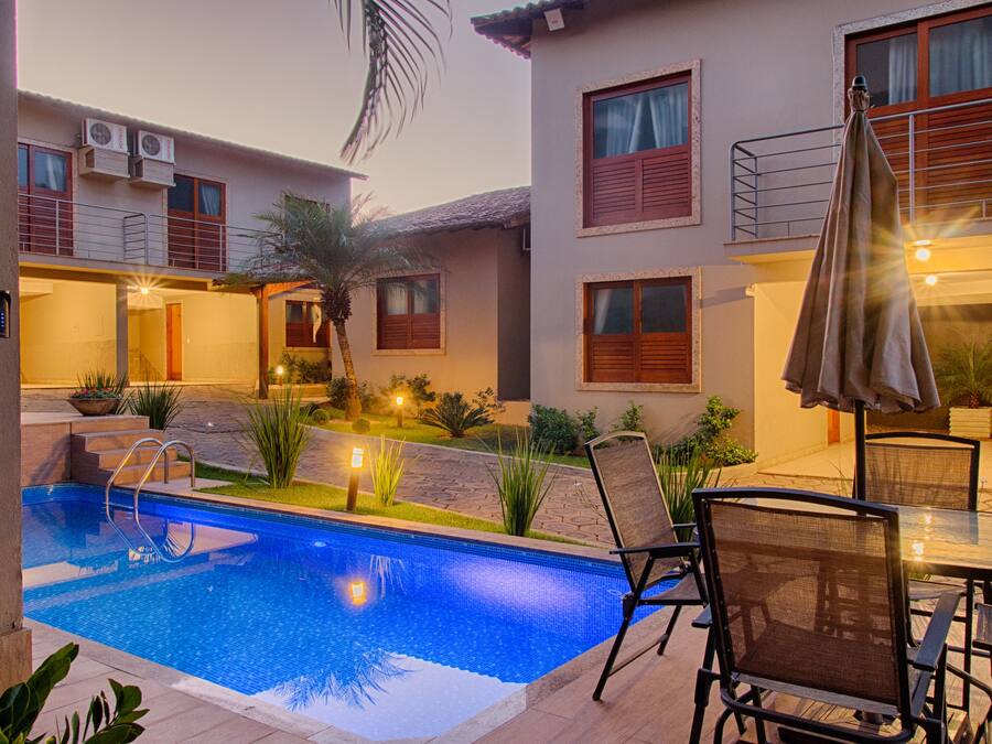 A swimming pool with a sunken bench, surrounded by outdoor seating and plants.
