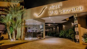 A hotel entrance with a checkmark sign, a reception desk, and a welcome sign.