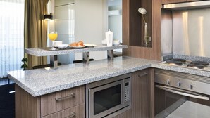 A modern kitchen with granite countertops, stainless steel appliances, and a breakfast bar.