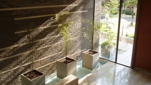 A modern interior with a brick wall and large windows. - Norus Las Condes (Santiago)