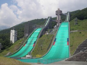 A ski slope with green running tracks and a control tower.
