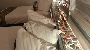 A hotel room with two beds, each with white linens and pillows, and a bedside table with a decorative arrangement of stones and leaves. - Lake View Suites (West Yellowstone)
