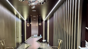 A modern hotel lobby with a reception desk, seating area, and decorative lighting. - Lake View Suites (West Yellowstone)