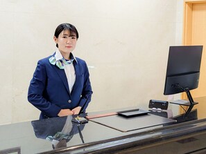 Un mostrador de recepción con un monitor de computadora, teclado y ratón.