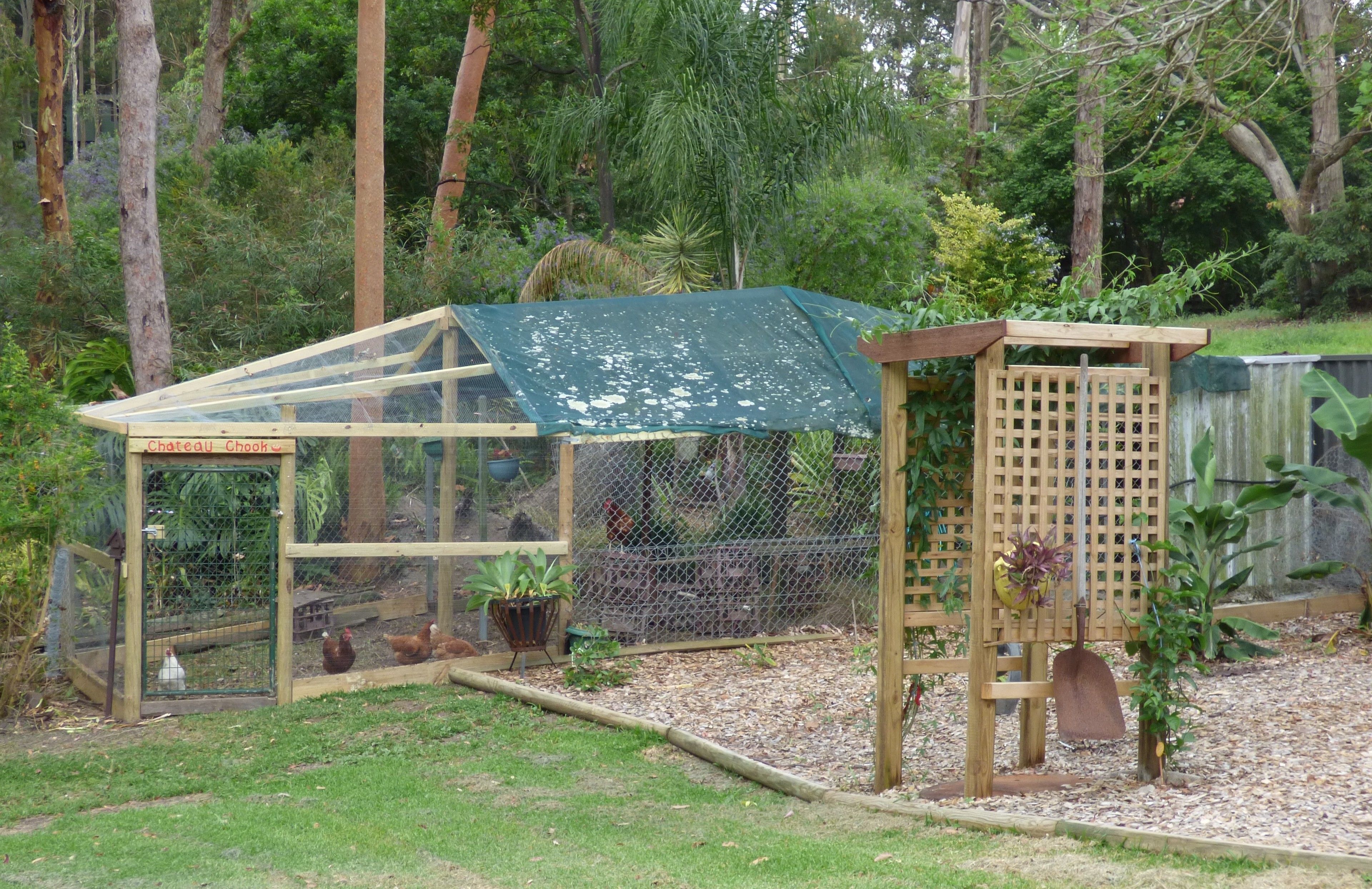 A chicken coop with a green roof and a wooden structure.