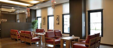 Un interior moderno con muebles de madera, ventanas amplias y elementos decorativos colgantes.