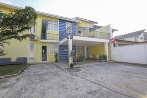 Stylish two-story residence with a covered entrance, potted plants, and a balcony.