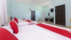 Une chambre d’hôtel avec deux lits, un bureau, une chaise, un ventilateur de plafond et une porte.
