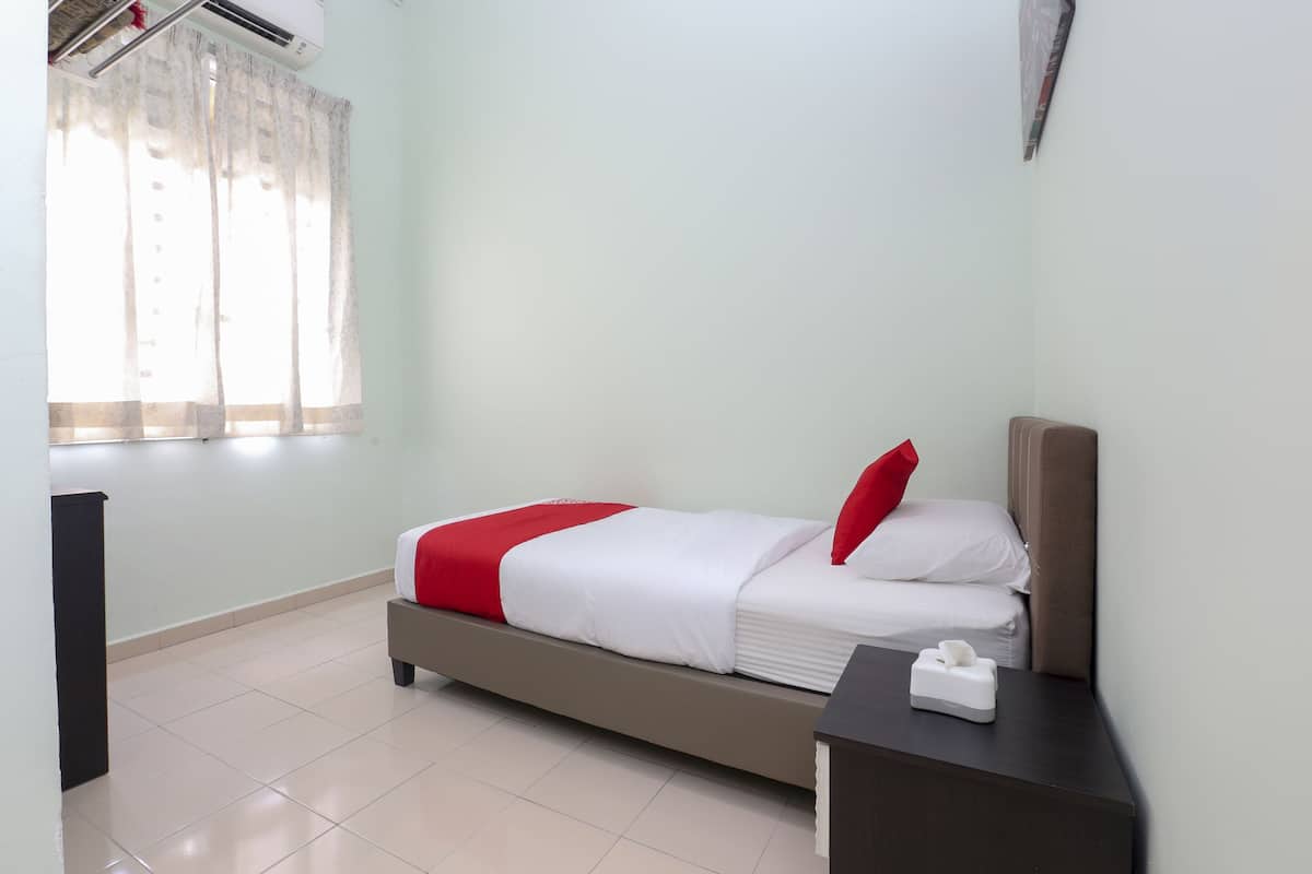 Habitación de hotel con cama, mesita de noche, ventana con cortinas y aire acondicionado instalado en la pared.