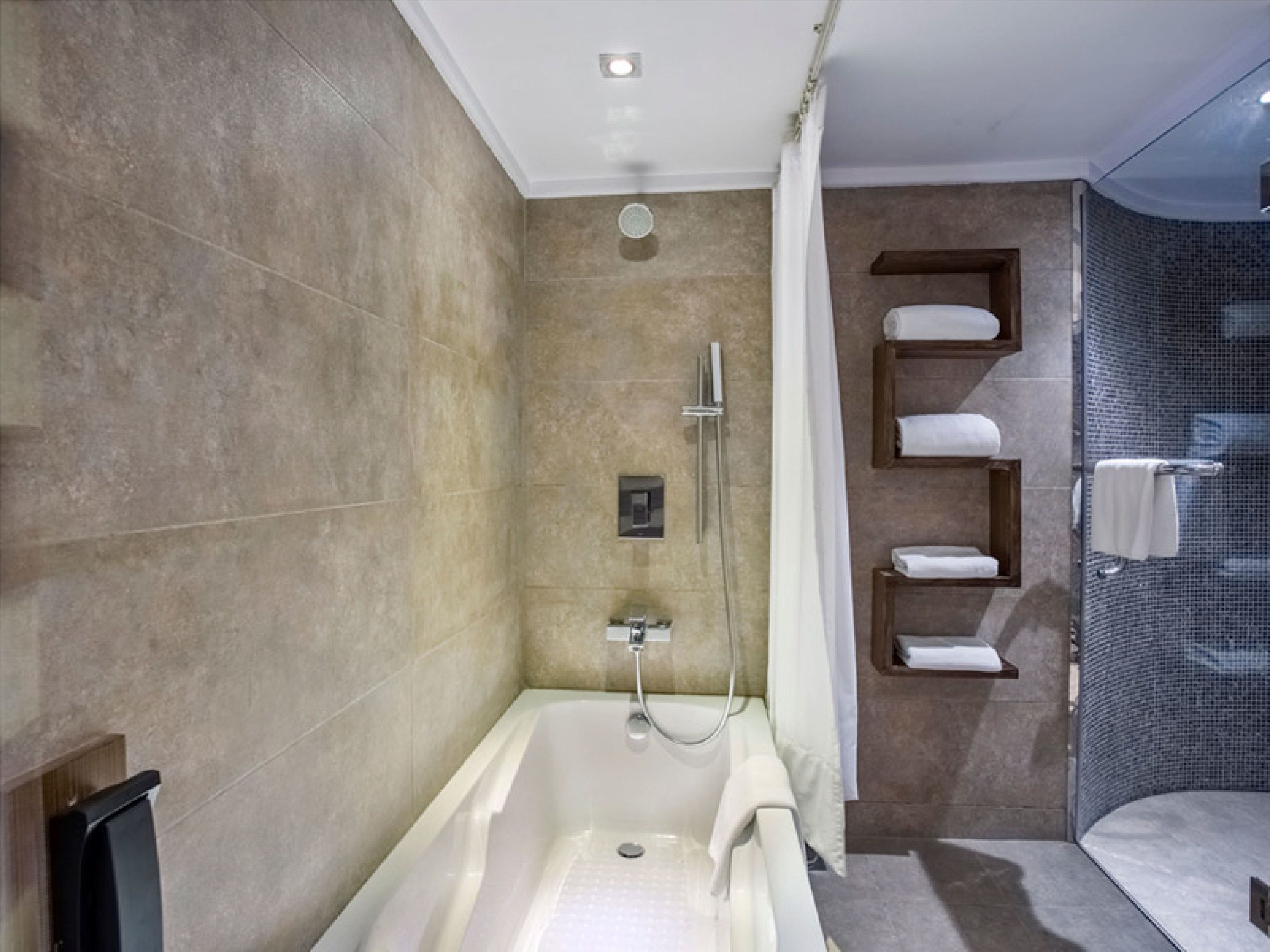 Ein modernes Badezimmer mit einer freistehenden Badewanne, einer Duschkabine und einer gläsernen Dusche.