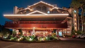 A hotel with a modern architectural design, featuring a prominent overhang and a well-lit entrance.