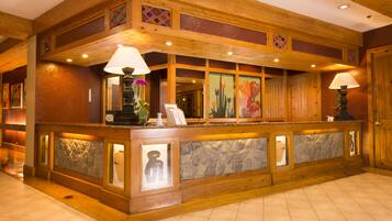 A reception area with a wooden reception desk, stone accents, and framed artwork.