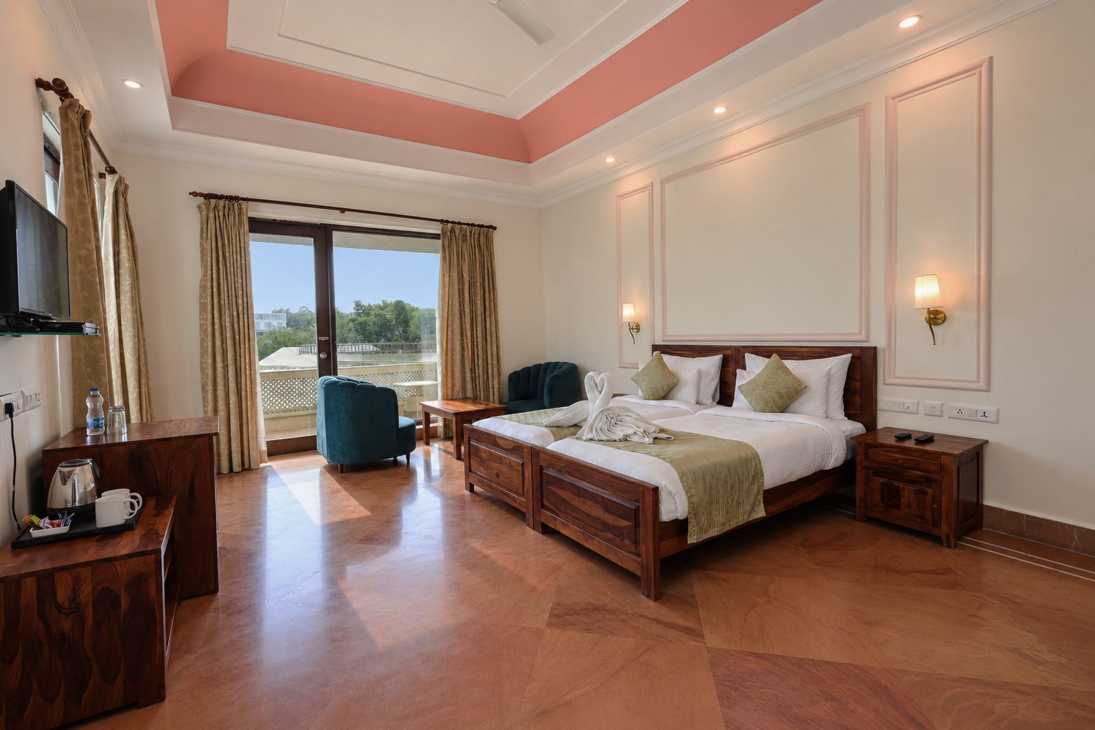 A hotel room with a large bed, a desk, a chair, a TV, and a balcony with curtains.