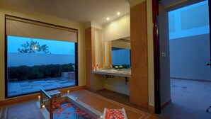 A modern bathroom with a large window, a bathtub, and a sink with a mirror above it. - Achrol Niwas A TreeHouse Hotel (Amer)